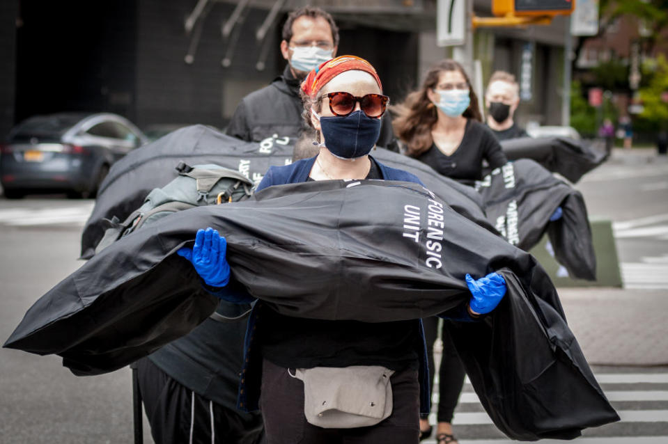 Activists from "Rise and Resist" and "Indivisible Brooklyn" carry body bags symbolising the victims who so far have died due to complications of COVID-19. Source: Getty 