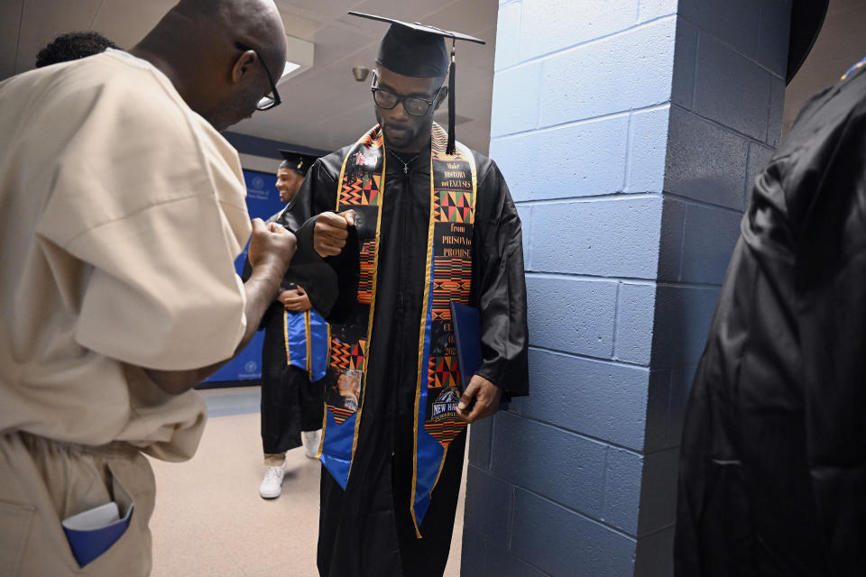 Graduate Marcus Harvin, right, fist bumps an inmate and fellow student at the first-ever college graduation ceremony at the MacDougall-Walker Correctional Institution on June 9.