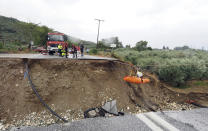 Firefighters use ropes to lift a kidney patient in a stretcher across a road damaged by a rainstorm in Kala Nera village, near Volos, central Greece, Wednesday, Sept. 6, 2023. The death toll from severe rainstorms that lashed parts of Greece, Turkey and Bulgaria increased Wednesday after rescue teams located the body of a missing vacationer who was swept away by flood waters that raged through a campsite in northwest Turkey. (AP Photo/Thodoris Nikolaou)