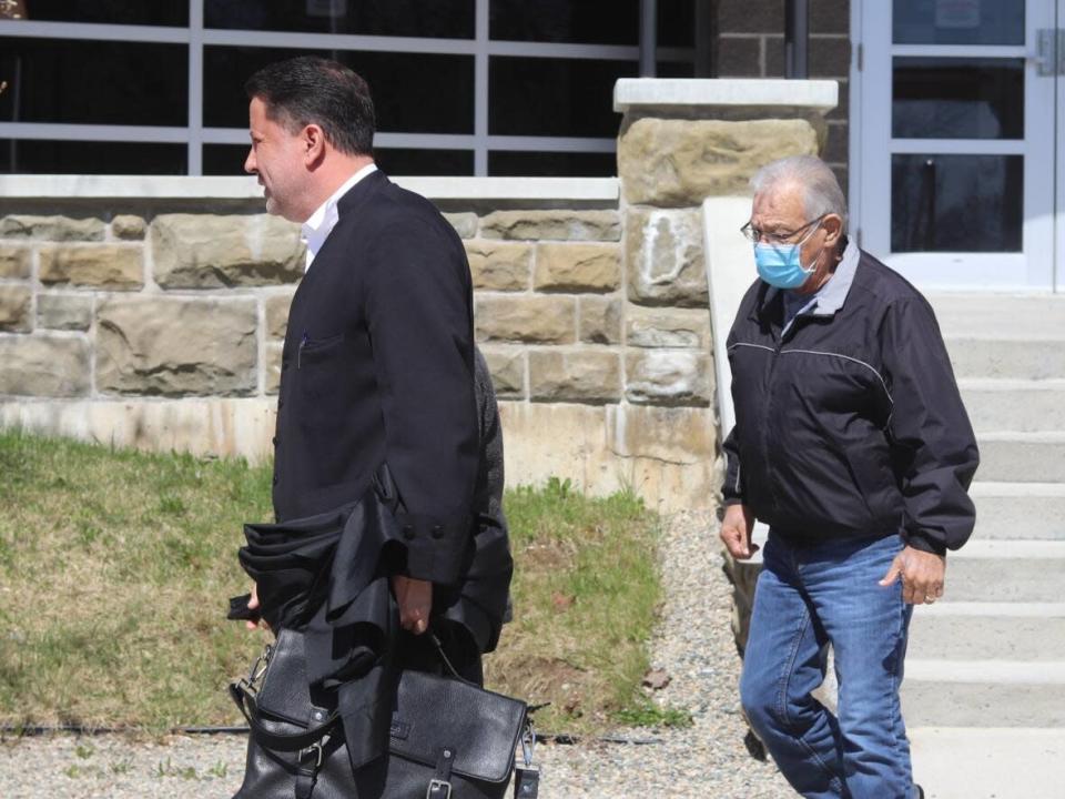 Wilbur Dedam, right, leaves the Miramichi courthouse last May with his lawyer T.J. Burke.  (Shane Magee/CBC - image credit)