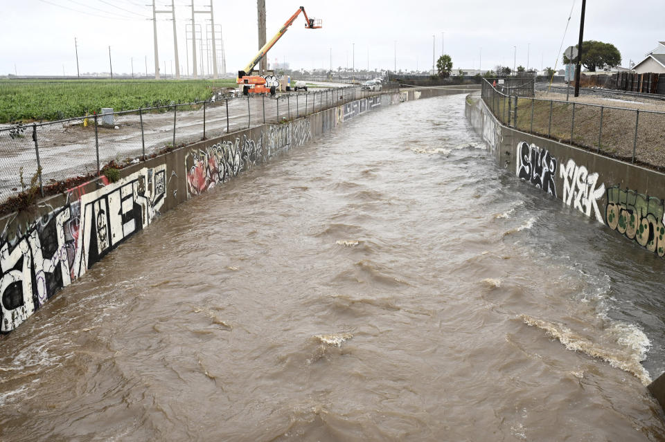 Runoff water fills the Ormond Lagoon Waterway, Thursday, Dec. 21, 2023, in Port Hueneme, Calif. A Pacific storm has pounded parts of Southern California with heavy rain, street flooding and a possible tornado, adding to hassles as holiday travel gets underway. (AP Photo/Michael Owen Baker)