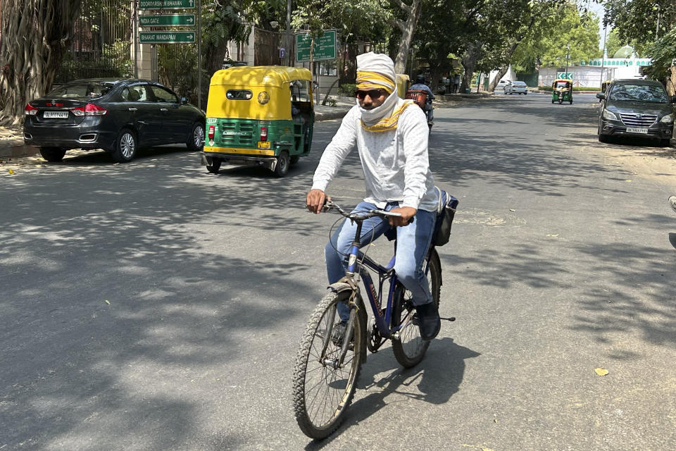 A cyclist has his head wrapped in a cotton scarf as protection from the heat in New Delhi, India, Saturday, May 18, 2024. Swathes of northwest India sweltered under scorching temperatures on Saturday, with the capital New Delhi under a severe weather alert as extreme temperatures strike parts of the country. (AP Photo/Shonal Ganguly)