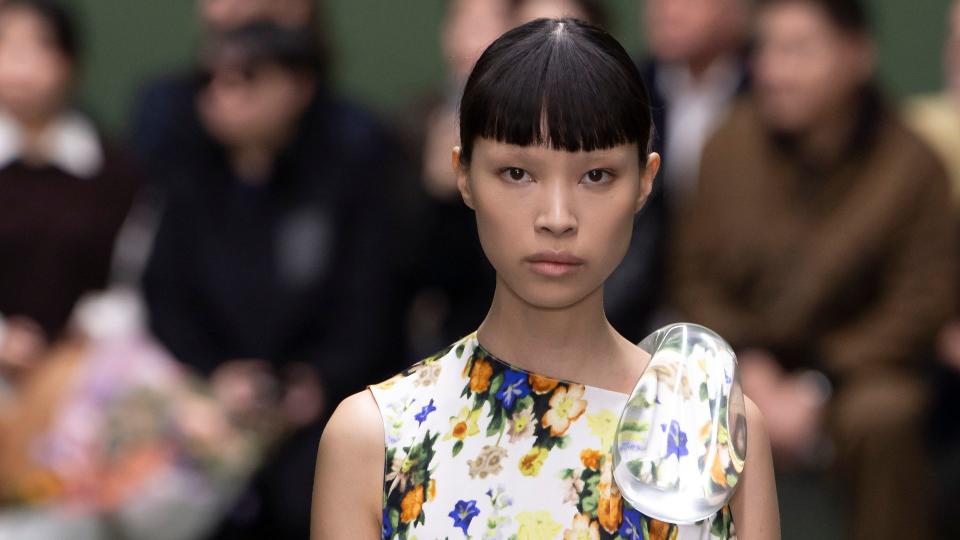 A model walks the runway during the Loewe Ready to Wear Fall/Winter 2024-2025 fashion show wearing a floral silk dress