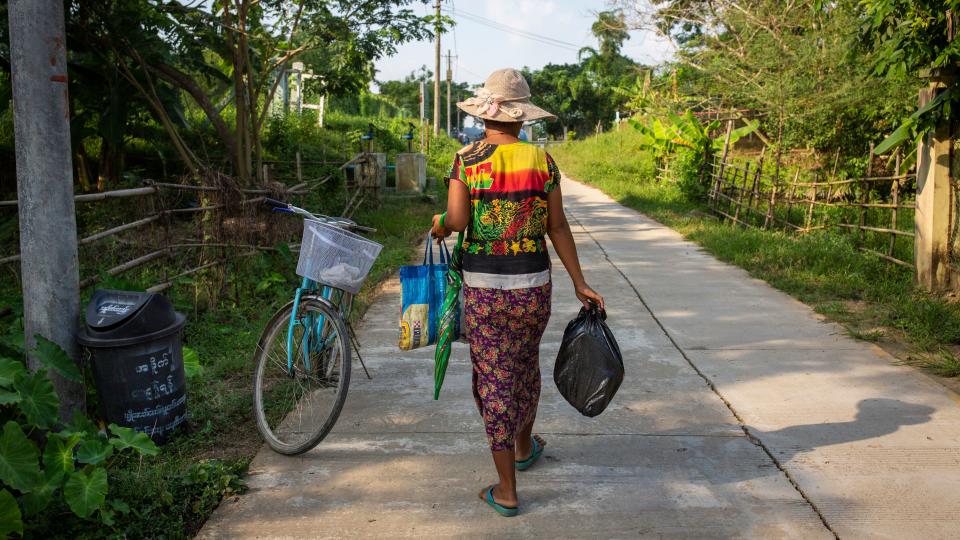 A woman carries a recycled bag and plastic bag. (Photo: Hkun Lat for HuffPost)