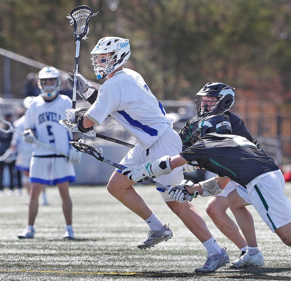 Clipper midfielder Austin Shea, center, takes a shot while under pressure from a pair of Marshfield players during a "Chowda Cup" semifinal game on Thursday, April 20, 2023.
