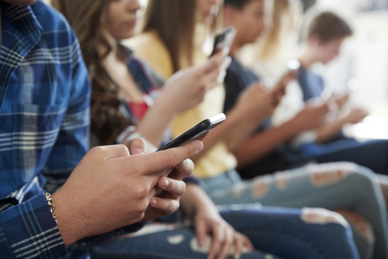 Close Up Of A Line Of High School Students Using Mobile Phones concussion
