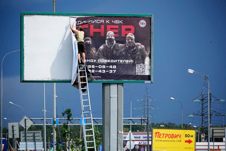 Un hombre retira el cartel con la leyenda 