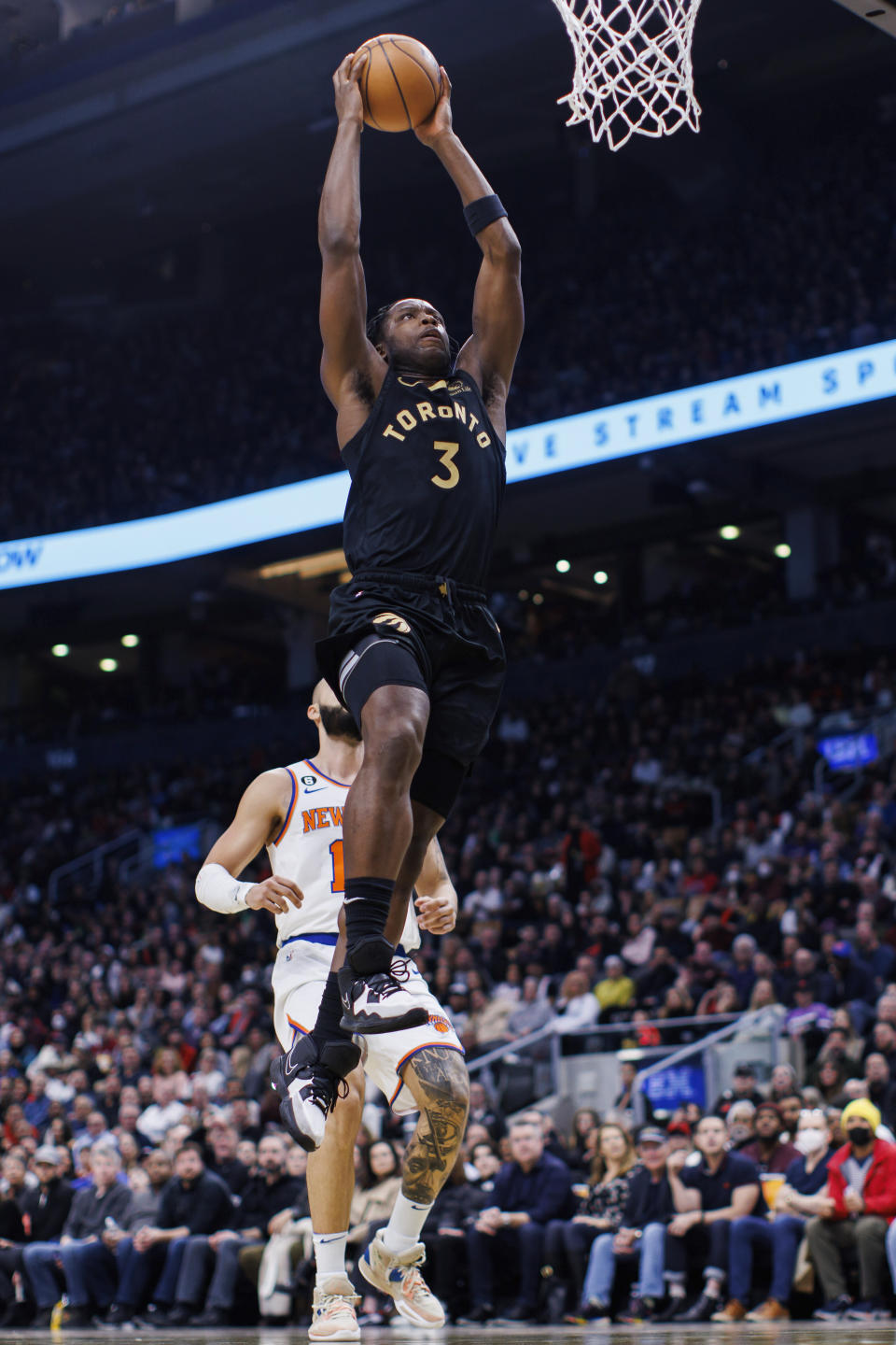 Toronto Raptors forward O.G. Anunoby (3) drives to the basket as New York Knicks guard Evan Fournier (13) looks on during the first half of an NBA basketball game Friday, Jan. 6, 2023, in Toronto. (Cole Burston/The Canadian Press via AP)