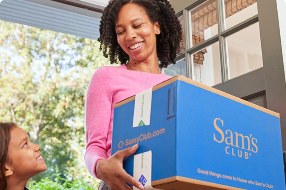 Mother and daughter at their front door with a Sam's Club delivery.