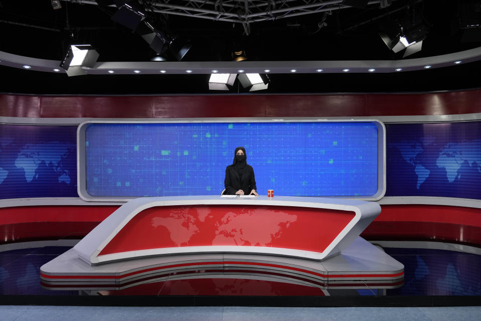 TV anchor Khatereh Ahmadi wears a face covering as she reads the news on TOLO NEWS, in Kabul, Afghanistan, Sunday, May 22, 2022. Afghanistan's Taliban rulers have begun enforcing an order requiring all female TV news anchors in the country to cover their faces while on-air. The move Sunday is part of a hard-line shift drawing condemnation from rights activists. (AP Photo/Ebrahim Noroozi)