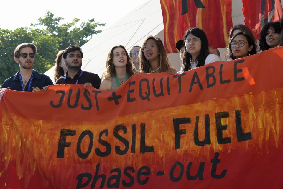 Mitzi Jonelle Tan, of the Philippines, center, gets emotional while participating in a demonstration against fossil fuels at the COP28 U.N. Climate Summit, Wednesday, Dec. 13, 2023, in Dubai, United Arab Emirates. (AP Photo/Peter Dejong)