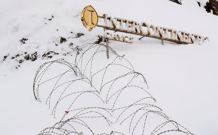 Barbed wire sticks out of the snow beside a logo of the InterContinental hotel in the Swiss Alps resort of Davos, Switzerland January 18, 2018. REUTERS/Arnd Wiegmann