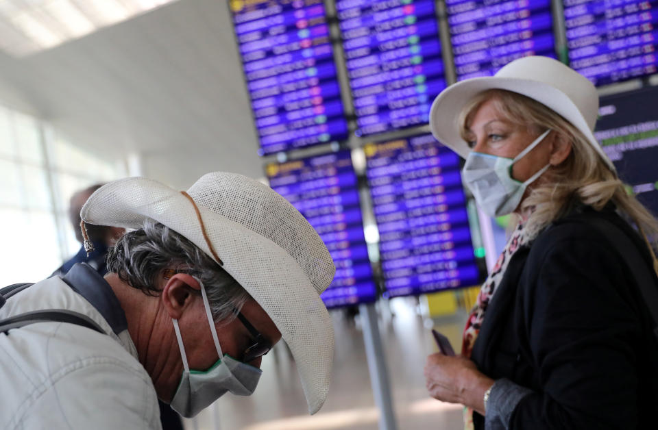 A woman from the Netherlands and her friend from Britain stand next to the display flight information at Josep Tarradellas Barcelona-El Prat Airport, as a case of novel coronavirus has been confirmed in Barcelona, Spain February 26, 2020. REUTERS/Nacho Doce