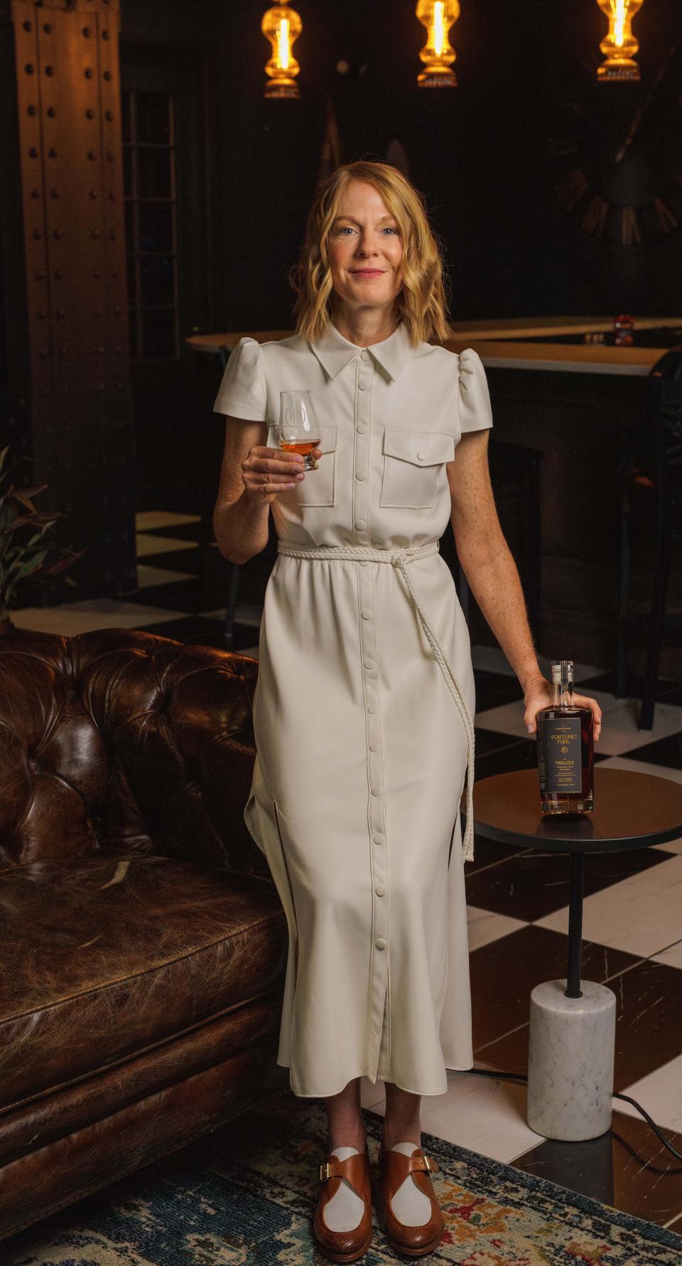 Fortune's Fool CEO Juliet Schmalz stands with a bottle of her debut whiskey, the Prelude