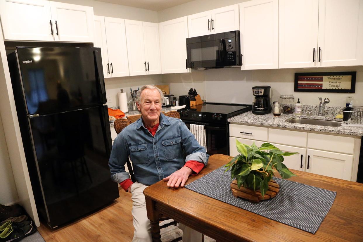 Champlin Place resident Rodd Hersey sits in his kitchen/dining area after recently moving into his new affordable apartment developed by Easterseals in Rochester.