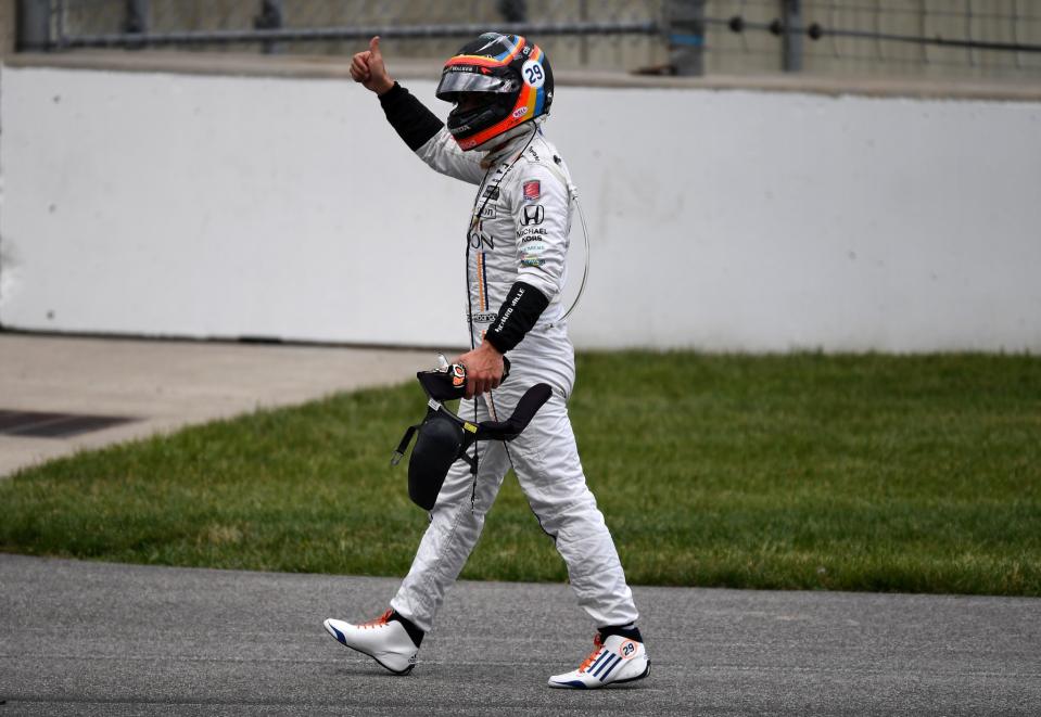 Fernando Alonso gestures to the crowd after getting out of his car. (Getty)