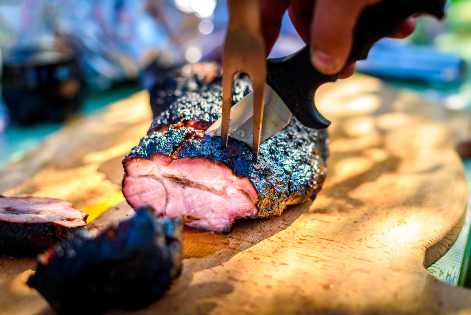 Slicing a big piece of barbecued meat.