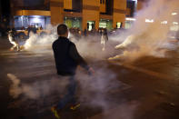 Protesters are seen surrounded by tear gas that was fired towards them by Lebanese riot police during an anti-government protest in Beirut, Lebanon, Wednesday, Dec. 4, 2019. Protesters have been holding demonstrations since Oct. 17 demanding an end to corruption and mismanagement by the political elite that has ruled the country for three decades. (AP Photo/Bilal Hussein)