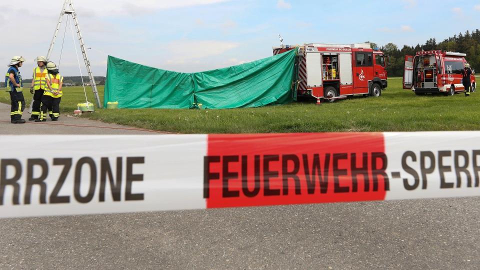 Feuerwehrleute haben auf dem Flugplatz einen Sichtschutz errichtet. Foto: Thomas Warnack