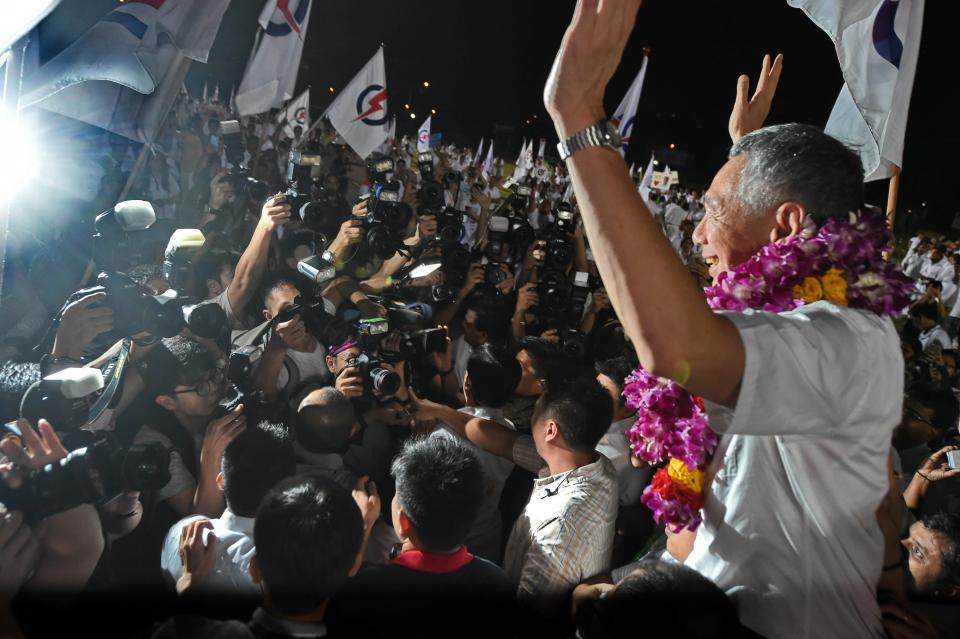 Singapore's Prime Minister Lee Hsien Loong, of the People's Action Party celebrates after winning the general election in Singapore on September 12, 2015. Singaporeans voted on September 11 in the most hotly contested election in the country's history after massive turnouts at opposition rallies boosted chances that a two-party system will emerge from half a century of domination by the ruling party. The People's Action Party (PAP), co-founded by the late independence leader Lee Kuan Yew and now led by his son, Prime Minister Lee Hsien Loong, is widely expected to retain a clear majority in the 89-seat parliament.  AFP PHOTO / ROSLAN RAHMAN        (Photo credit should read ROSLAN RAHMAN/AFP via Getty Images)