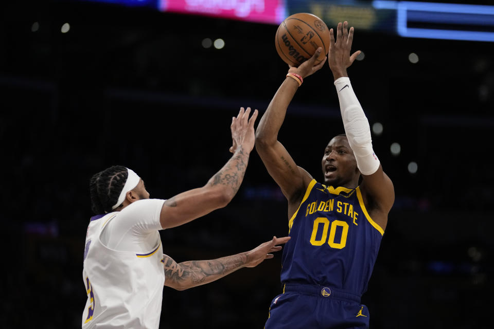 Golden State Warriors forward Jonathan Kuminga (00) shoots against Los Angeles Lakers forward Anthony Davis (3) during the first half of an NBA basketball game in Los Angeles, Saturday, March 16, 2024. (AP Photo/Ashley Landis)
