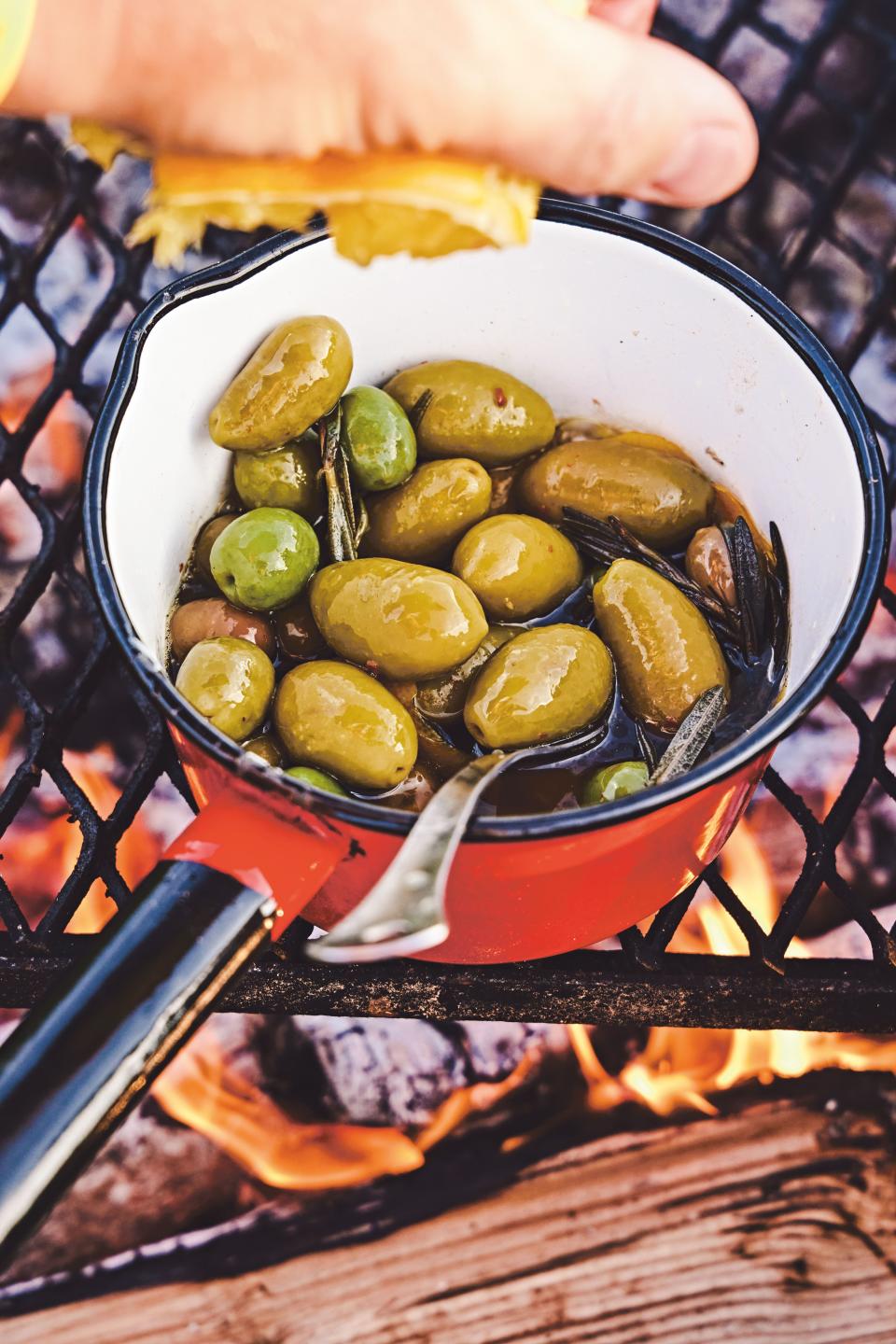 Headed camping? Heating olives over the open fire (or in a saucepan on the stove or grill) utterly transforms them into a smoky snack perfumed with herbs. Spoon them over grilled fish or serve as a side to fire-kissed <a href="https://www.epicurious.com/recipes/food/views/perfect-pork-chops-51206430?mbid=synd_yahoo_rss" rel="nofollow noopener" target="_blank" data-ylk="slk:pork chops;elm:context_link;itc:0" class="link ">pork chops</a>. <a href="https://www.epicurious.com/recipes/food/views/campfire-olives?mbid=synd_yahoo_rss" rel="nofollow noopener" target="_blank" data-ylk="slk:See recipe.;elm:context_link;itc:0" class="link ">See recipe.</a>
