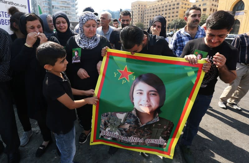 Kurds living in Lebanon react as they hold Hevrin Khalaf's picture, a Kurdish politician who was killed in Syria, during a protest against Turkey's military action in northeastern Syria