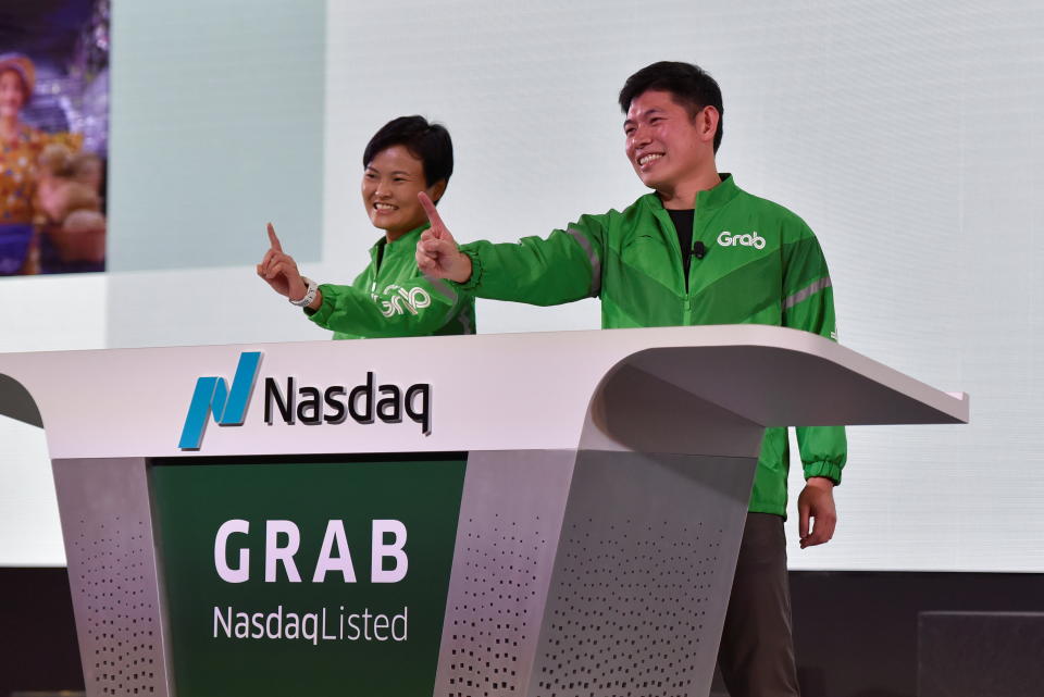 Grab's CEO Anthony Tan and co-founder Tan Hooi Ling gesture on stage as they attend the Grab Bell Ringing Ceremony at a hotel in Singapore, December 2, 2021. REUTERS/Caroline Chia