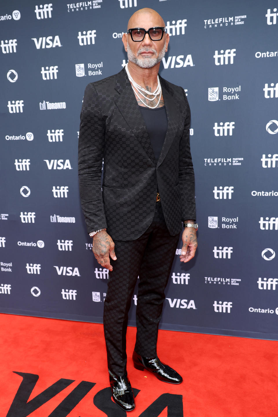 Dave Bautista attends the premiere of "The Last Showgirl" at the 2024 Toronto International Film Festival in Gucci suit, pearl necklace, diamond bracelets, men's jewelry