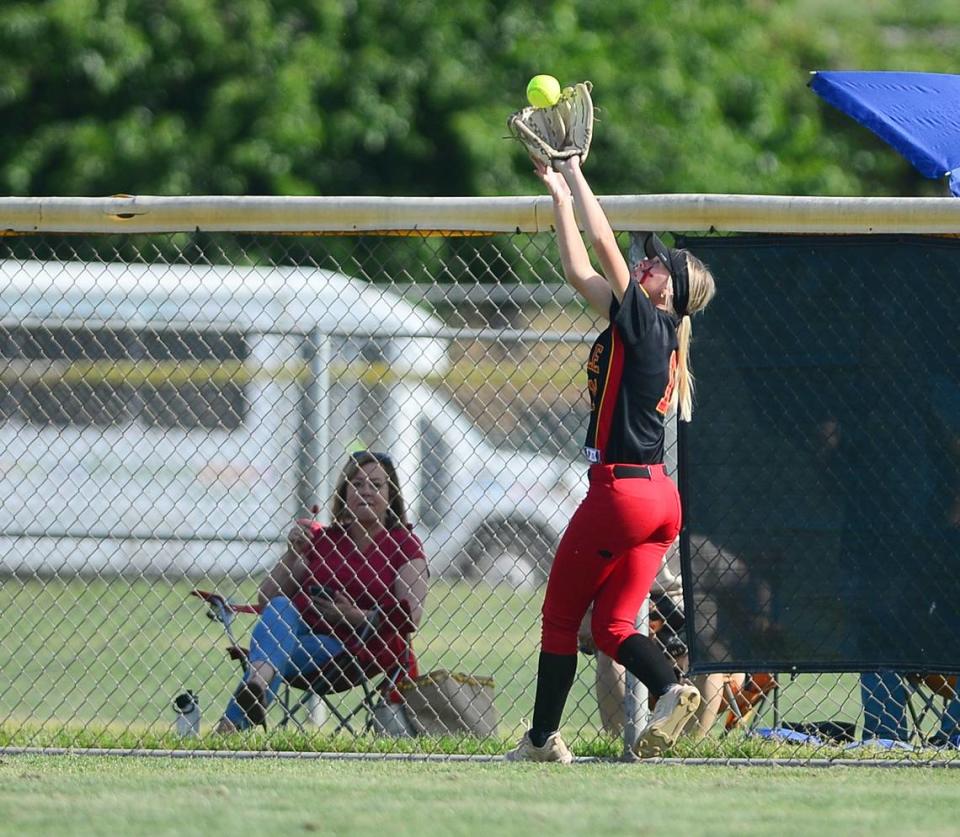 Oakdale outfielder Bailey Peterson (11) makes a catch by the center field wall during a game between Oakdale and Central Catholic at Oakdale High School in Oakdale, Calif. on April 17, 2024. Central Catholic won 6-2.