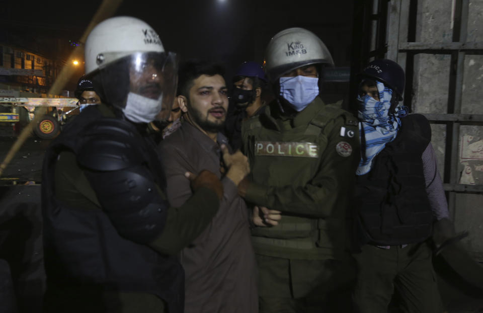 Police officers detain a supporters of Tehreek-e-Labiak Pakistan, a radical Islamist political party, during their march toward Islamabad, in Lahore, Pakistan, Friday, Oct. 22, 2021. Thousands of Islamists launched their "long march" from the eastern city of Lahore toward Pakistan's capital, demanding that the government release the leader of their Saad Rizvi, who was arrested last year amid demonstrations against France over publishing caricatures of Islam's Prophet Muhammad. (AP Photo/K.M. Chaudary)