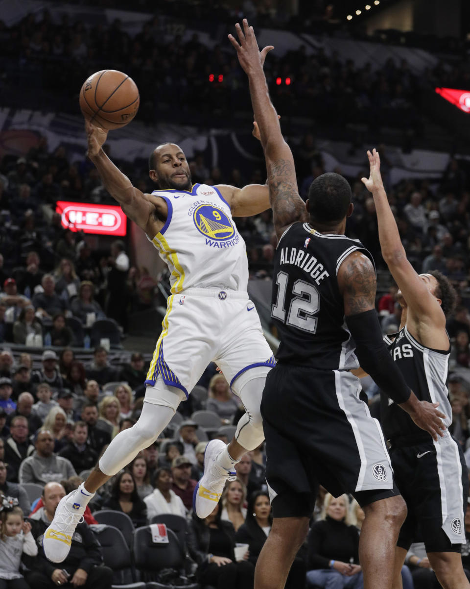 Golden State Warriors guard Andre Iguodala (9) looks to pass the ball as San Antonio Spurs forward LaMarcus Aldridge (12) defends during the first half of an NBA basketball game Sunday, Nov. 18, 2018, in San Antonio. (AP Photo/Eric Gay)