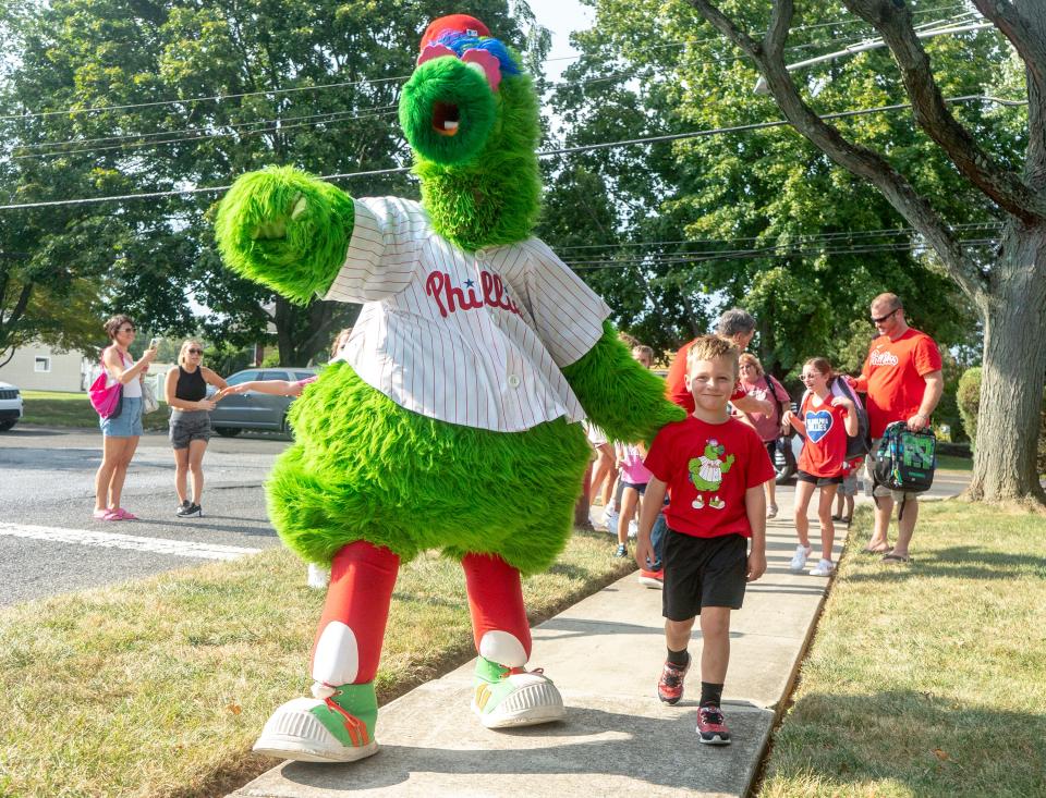 The Phillie Phanatic walks Rowan Linder, a 5 year-old big-time baseball fan who is battling cancer, to his house from the bus stop before being surprised with a newly redecorated Phillies-themed bedroom in Middletown on Thursday, Sept. 7, 2023.

[Daniella Heminghaus | Bucks County Courier Times]