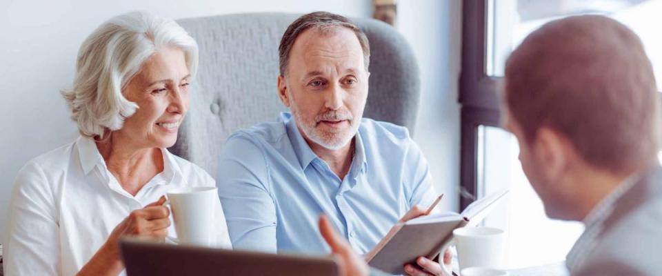 Positive older couple consulting with insurance agent