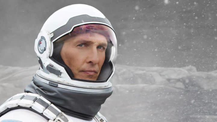 Matthew McConaughey as Cooper in his astronaut suit looking to the distance in Interstellar.