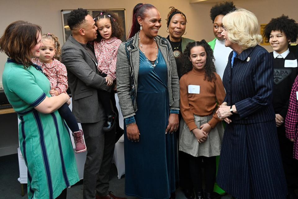 Camilla, Queen Consort, speaks with Marie Hanson (C), Chief Executive of S.T.O.R.M Family Centre and guests