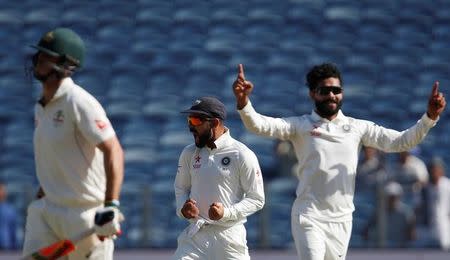 Cricket - India v Australia - First Test cricket match - Maharashtra Cricket Association Stadium, Pune, India - 25/02/17. India's Ravindra Jadeja celebrates with team mate Virat Kohli (C) the wicket of Australia's Mitchell Marsh (L). REUTERS/Danish Siddiqui