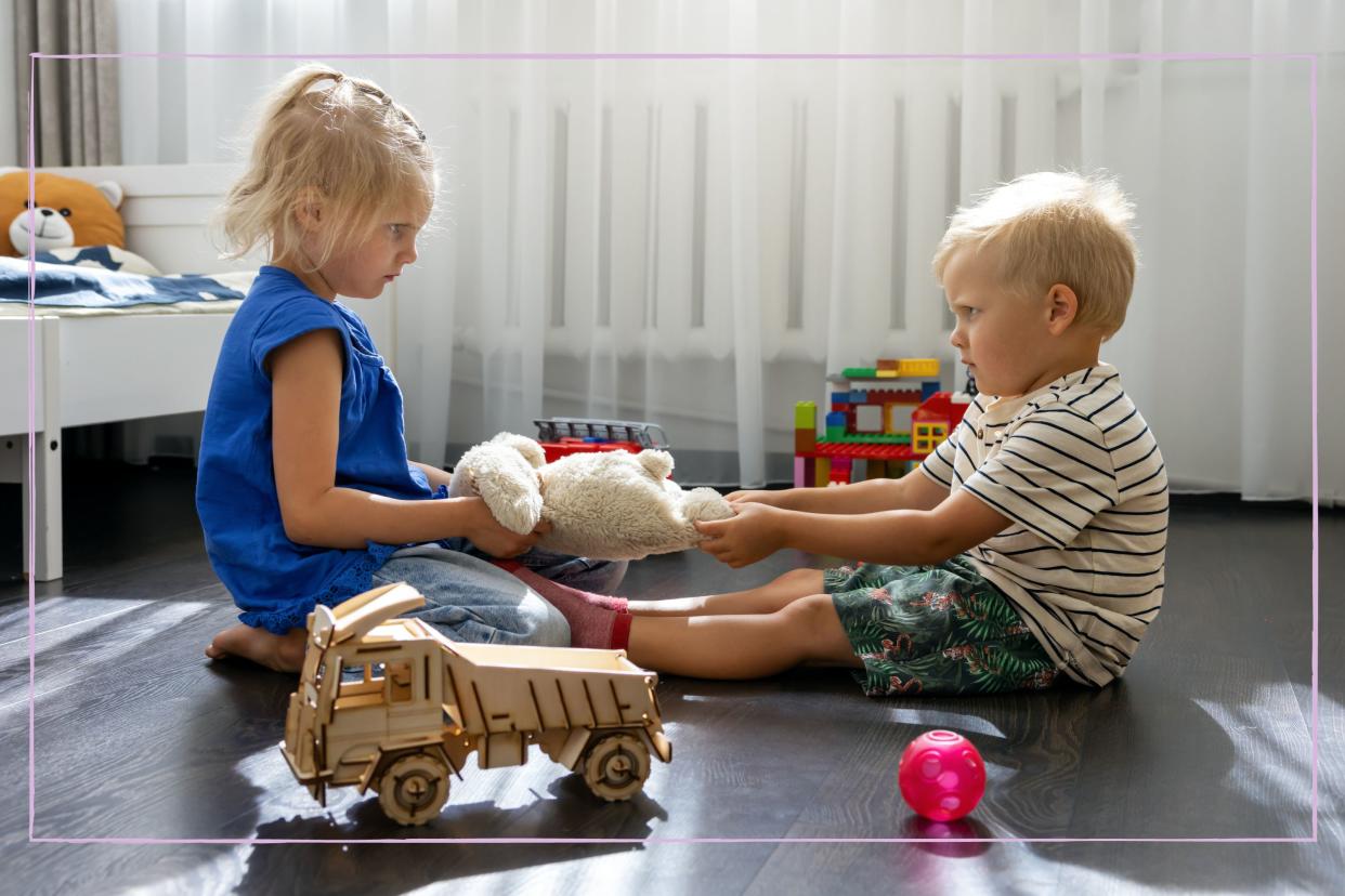  Two toddlers fighting over a toy. 