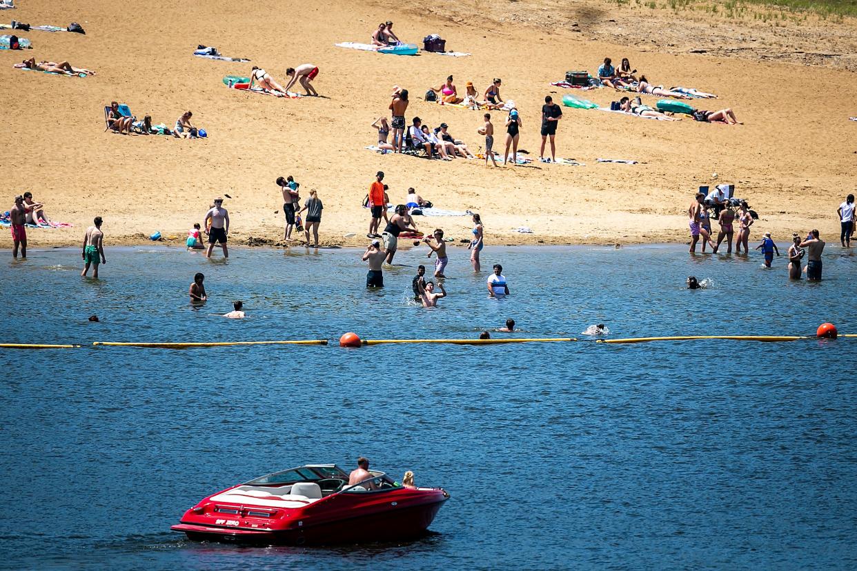 People lounge on the beach and play in the water on Memorial Day, Monday, May 29, 2023, at the Coralville Lake in Johnson County, Iowa.