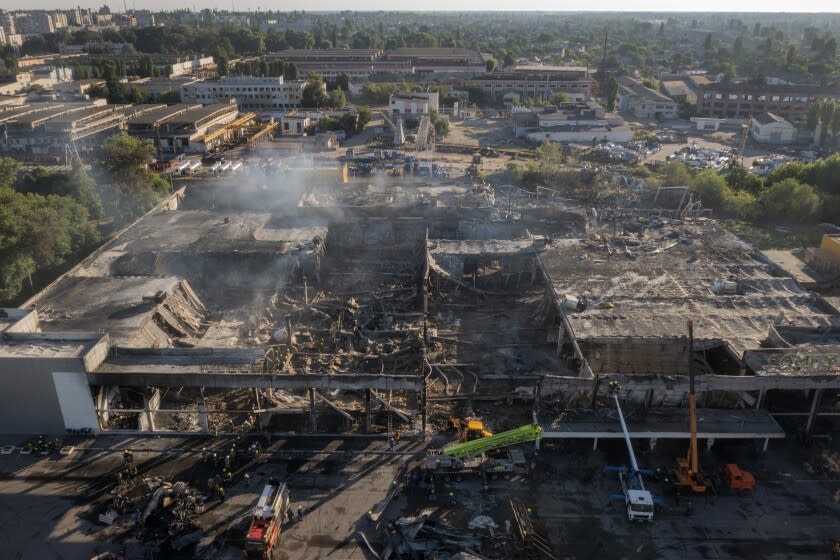 Ukrainian State Emergency Service firefighters work to take away debris at a shopping center burned after a rocket attack in Kremenchuk, Ukraine, Tuesday, June 28, 2022. (AP Photo/Efrem Lukatsky)