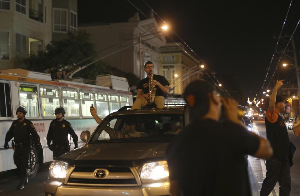 A man plays a saxophone atop a vehicle as fans celebrate in the Mission District after the San Francisco Giants defeated the Kansas City Royals in Game 7 of the World Series, in San Francisco, California October 29, 2014. (REUTERS/Robert Galbraith)