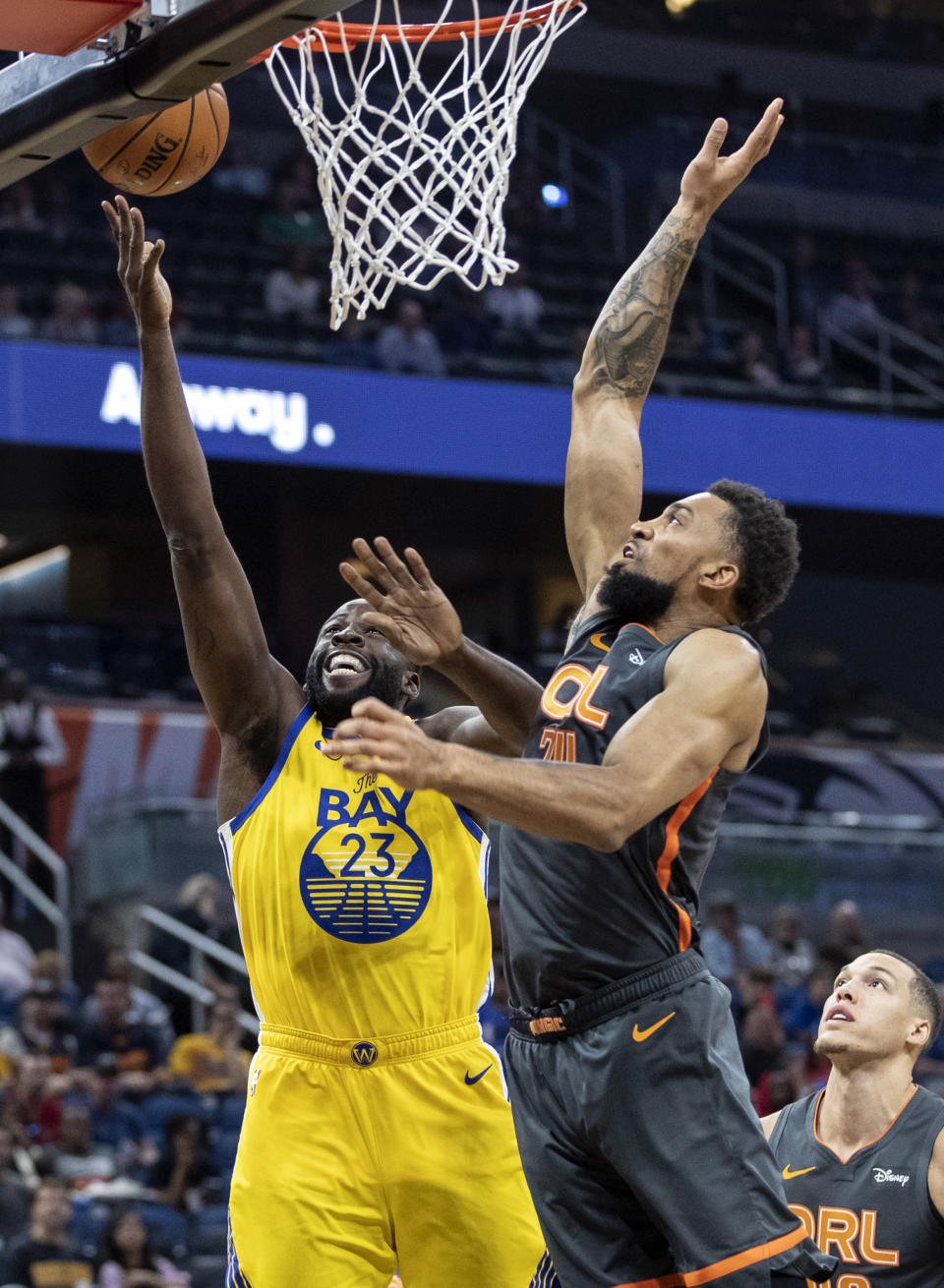 Golden State Warriors forward Draymond Green (23) lays the ball up on Orlando Magic center Khem Birch (24) during the first half of an NBA basketball game, Sunday, Dec. 1, 2019, in Orlando, Fla. (AP Photo/Willie J. Allen Jr.)