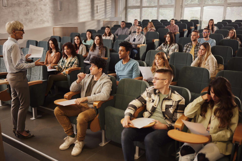 Instructor addressing a group of students in a lecture hall