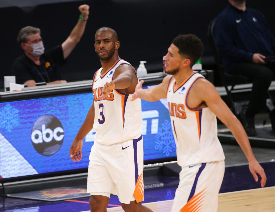 Phoenix Suns guard Chris Paul (3) congratulates guard Devin Booker (1) after a basket during the fourth quarter against the Dallas Mavericks at Talking Stick Resort Arena in Phoenix Dec. 23, 2020.