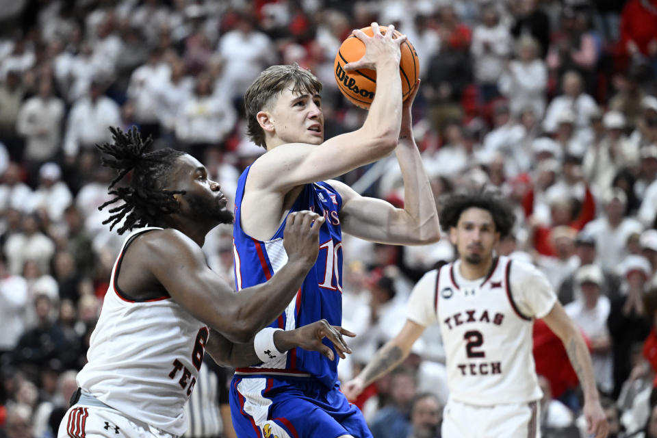 Kansas guard Johnny Furphy, front right, drives to the basket against Texas Tech guard Joe Toussaint (6) during the second half of an NCAA college basketball game, Monday, Feb. 12, 2024, in Lubbock, Texas. (AP Photo/Justin Rex)