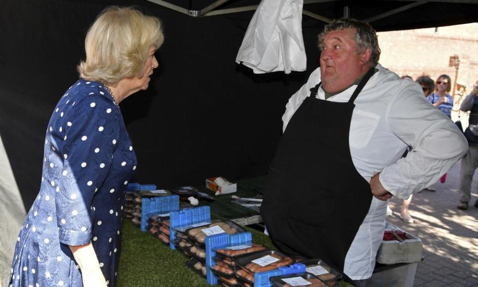 The Duchess of Cornwall speaks to a butcher in Salisbury