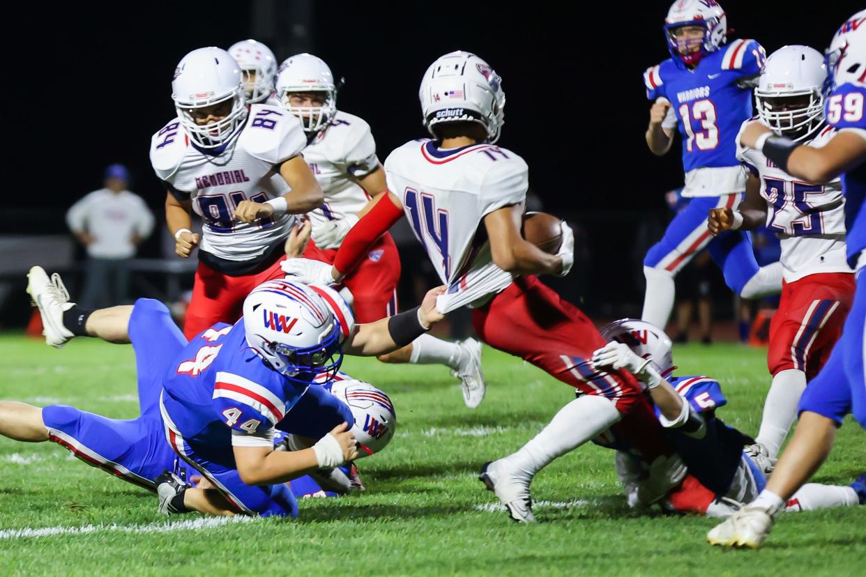 Memorial's Ethan Vilgrain is tackled by Winnacunnet's Dom Mancini (5) and Logan Brown (44) during Friday's Division I football game.