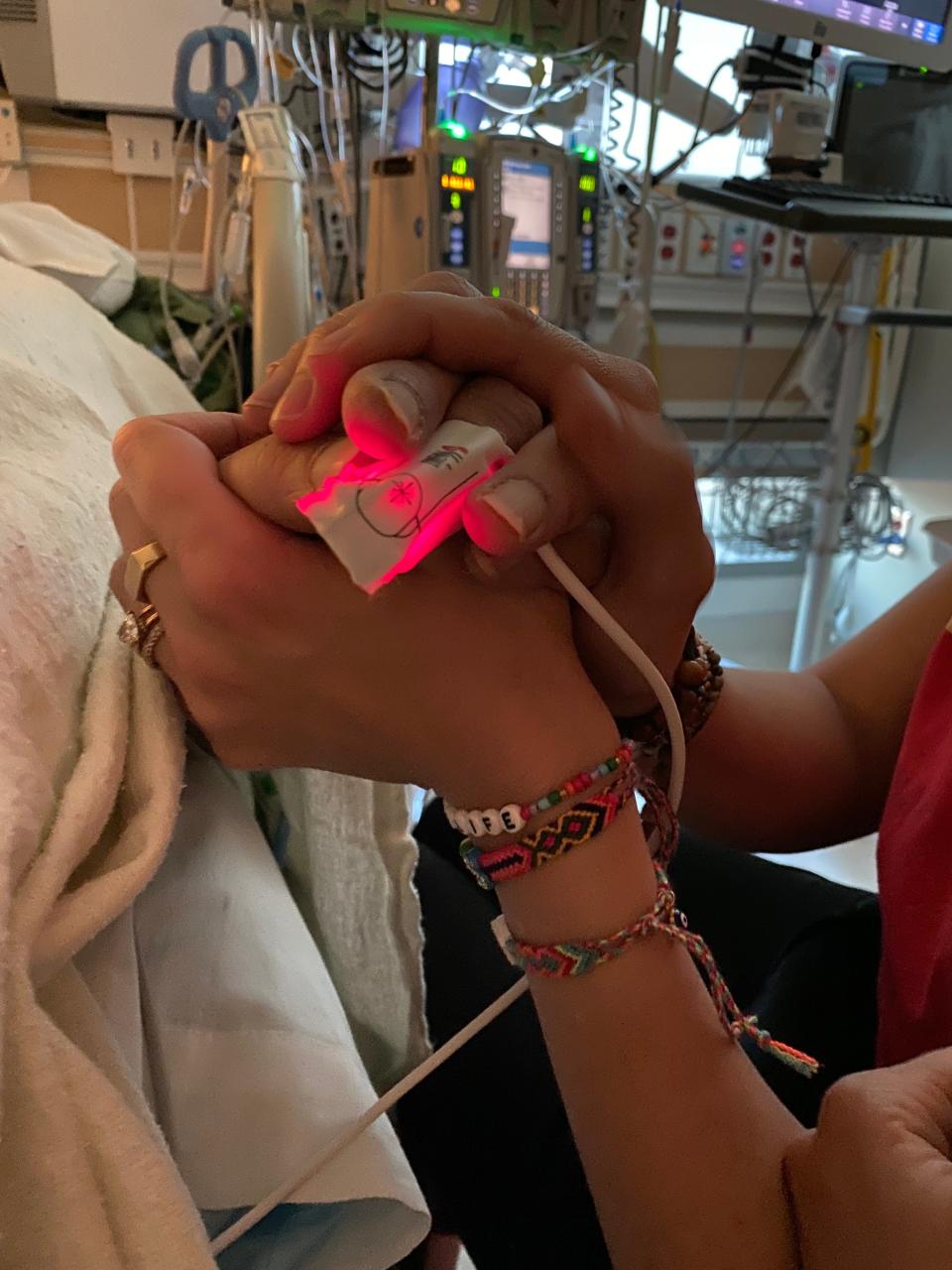 Amanda Kloots holds husband Nick Cordero's hand at the hospital. He died July 5, 2020, from severe COVID-19 complications.