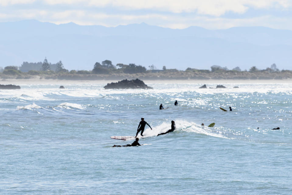 Surfers are seen at Scarborough Beach in Christchurch, New Zealand. 
