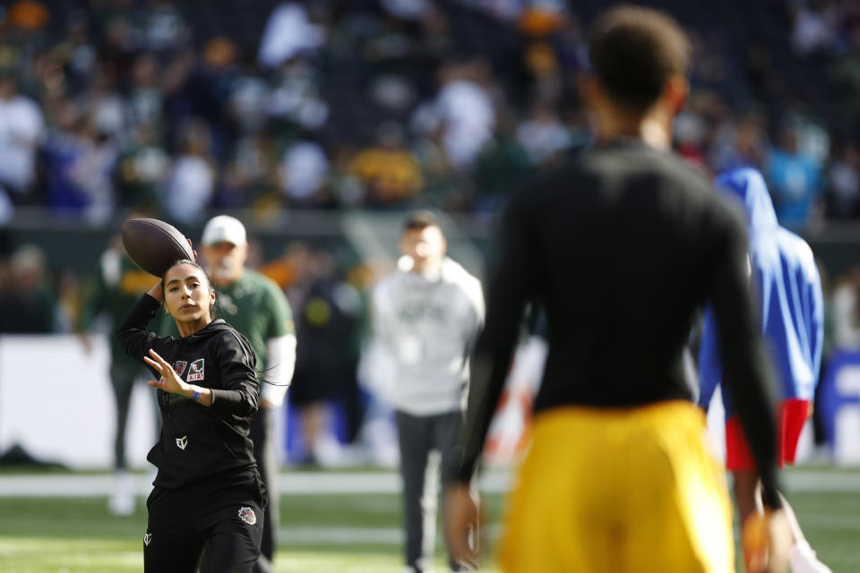 FILE - Team Mexico Women's Flag quarterback Diana Flores plays catch with Green Bay Packers wide receiver Allen Lazard (13) before an NFL football game between the Green Bay Packers and the New York Giants at Tottenham Hotspur Stadium in London, Sunday, Oct. 9, 2022. (AP Photo/Steve Luciano, File)